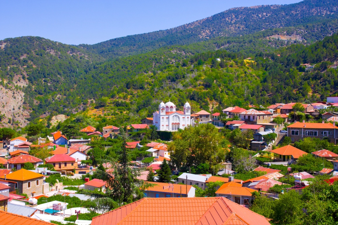 'Mountain Village Pedoulas, Cyprus. View over roofs of houses, mountains and Big church of Holy Cross. Village is one of most picturesque villages of Troodos mountain range ' - кипр